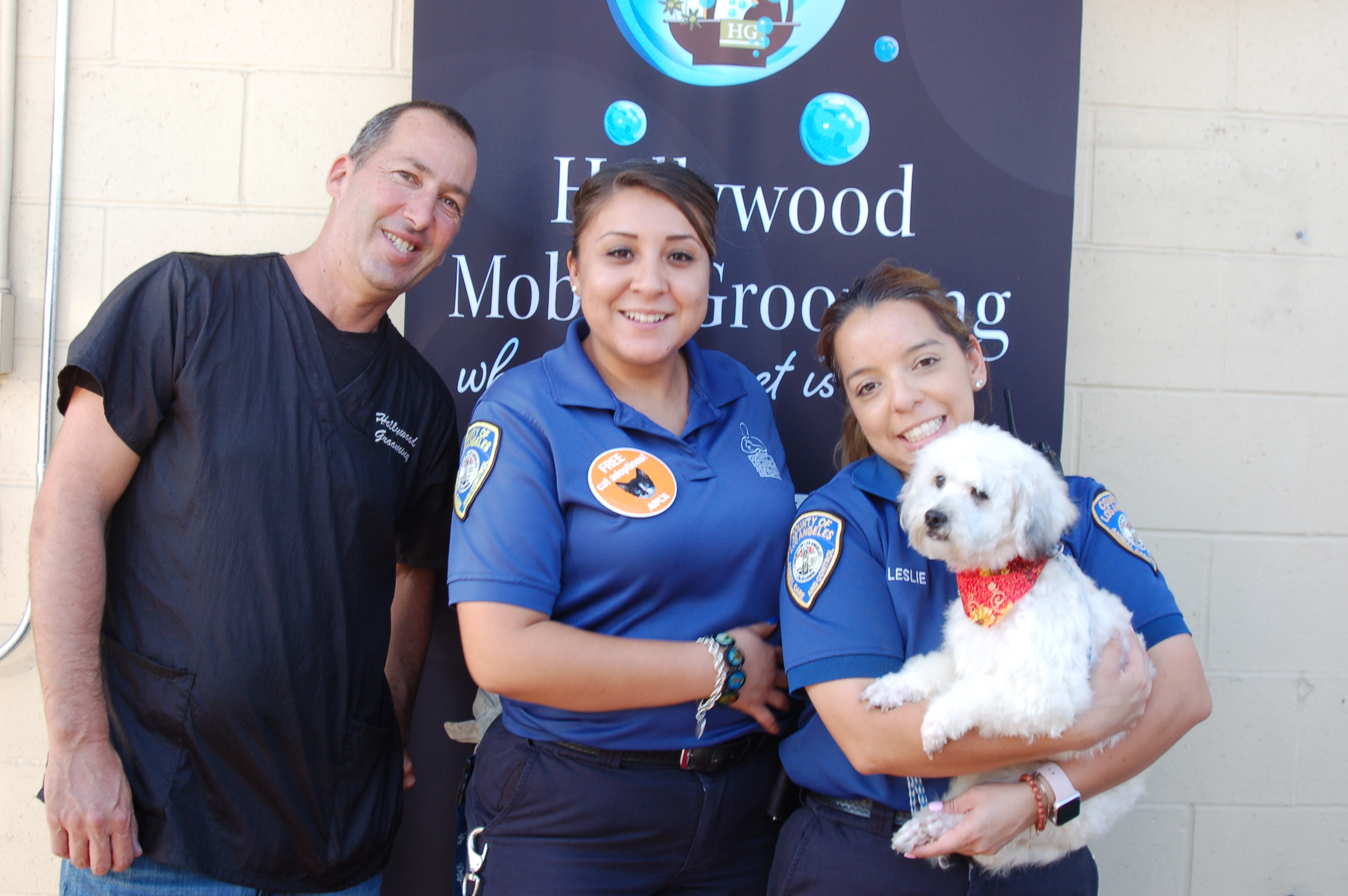 Chuck and team members hold a dog at a Community Event.