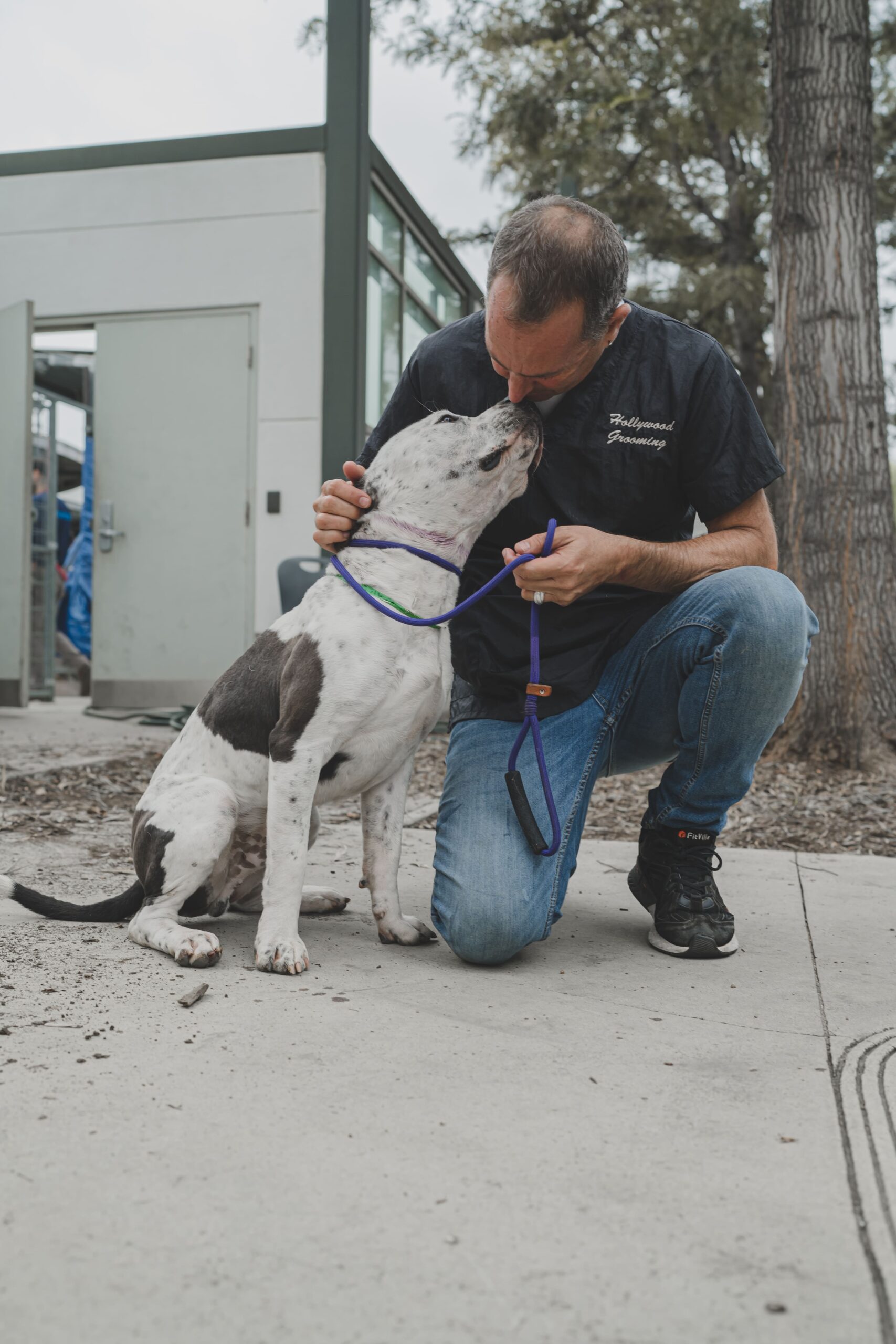 Chuck, Owner of Go Hollywood Grooming holding a small dog.